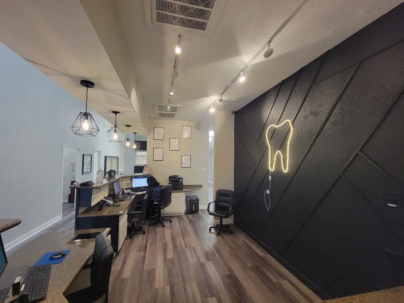 The reception hallway and tooth logo wall at Harwood Family Dental