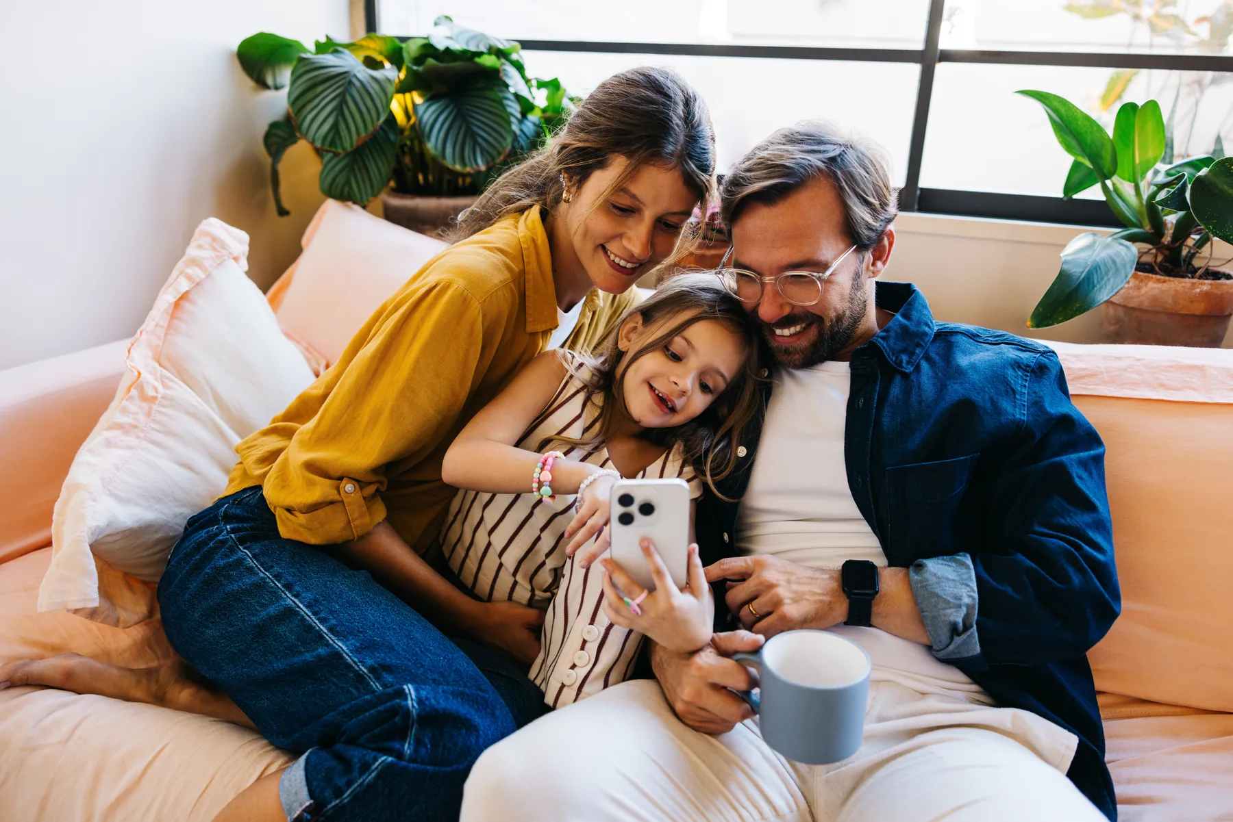Smiling family sitting on a couch with a dog